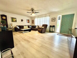 A living room with a sofa, armchair, coffee table, and a ceiling fan. - 4-bedroom house in Beautiful Delray Beach ! (Delray Beach)