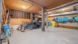 Tilava autotalli, jossa on pyöriä, lastenvaunut ja erilaisia säilytystarvikkeita.
