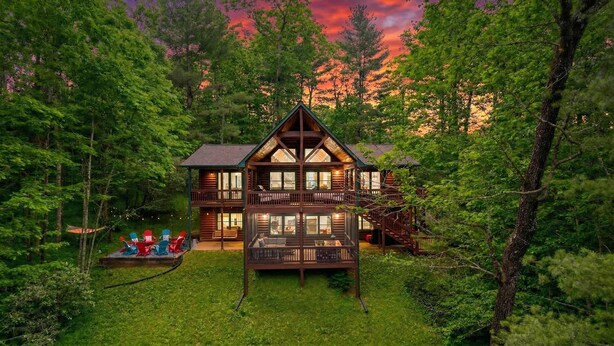 Eine Blockhütte mit Balkon, umgeben von dichtem Wald.