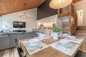 Ein modernes Interieur mit Essbereich für zwei Personen, einer Küche und einer Treppe.