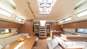 A compact interior with a dining area, kitchenette, and a small sleeping space. - Sun-Kissed Sailing Adventure in Islas Sarónicas (Alimos)