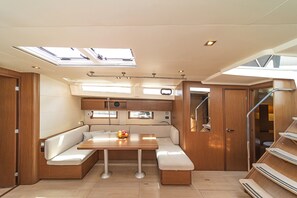 A compact, well-lit interior with a central seating area, a small table, and a skylight above.