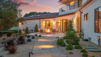A modern house with a patio, outdoor seating, and a fire feature.