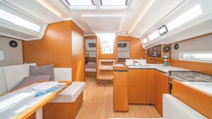 Een compact interieur met een kitchenette, zithoek en een klein bed.