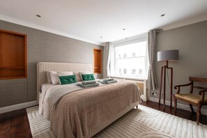 A bedroom with a bed, a chair, a lamp, and a window. - Prime Kensington Private Townhouse-Central London (London)