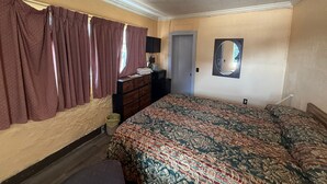 Une chambre à coucher avec un lit, une commode, un miroir et une fenêtre avec des rideaux.
