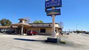 Un motel con un letrero que dice 'Sunset Lodge' y una dirección web.