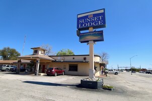 Un motel con un letrero que dice 'Sunset Lodge' y una dirección web.