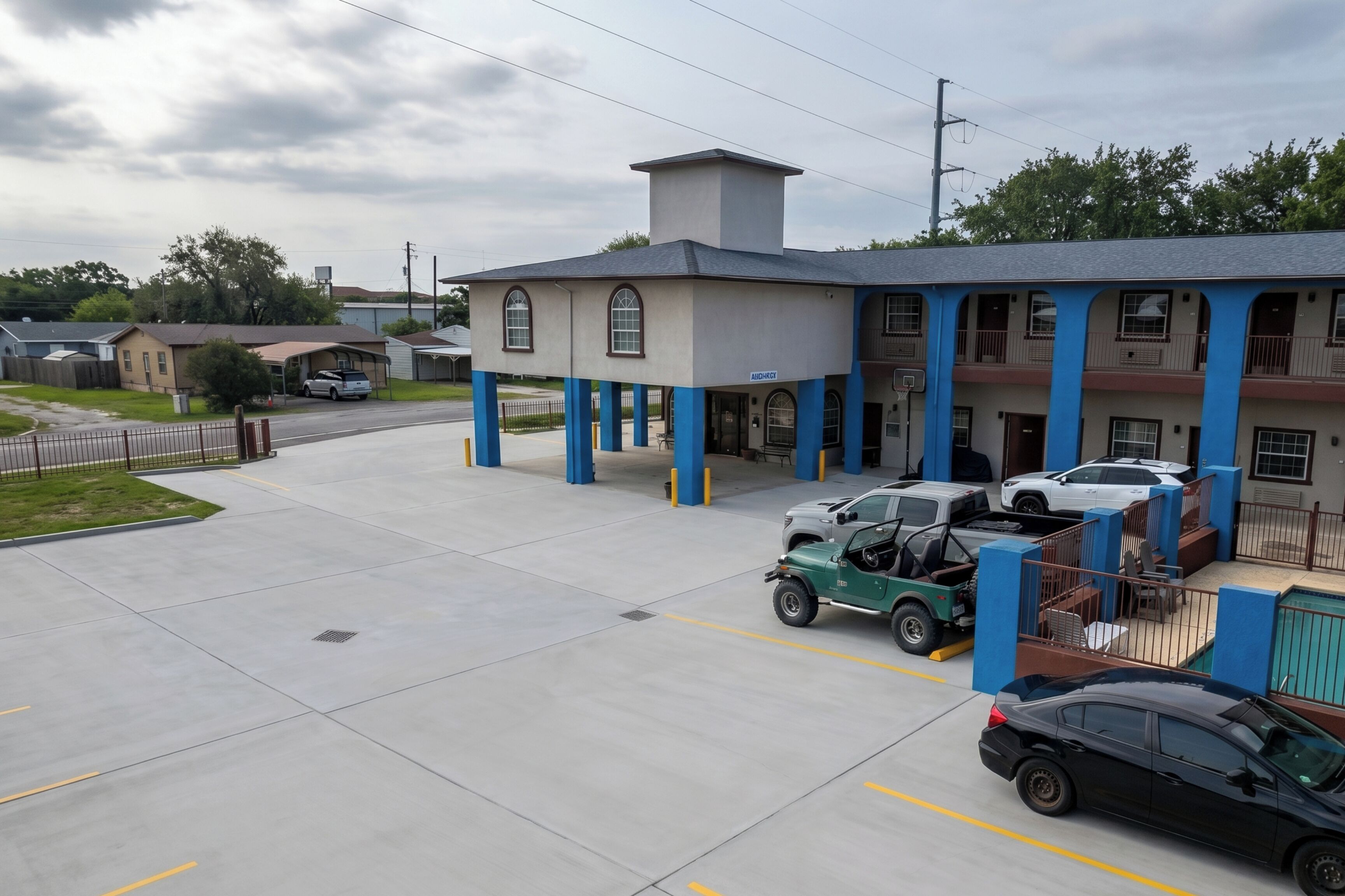 A building with a garage, a parking lot, and a street view.