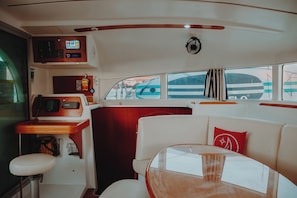 A boat interior with a control panel, seating area, and windows. - Sun-Kissed Sailing: A Luxurious Beach Experience in Nikiti, Macedonia (Nikiti)