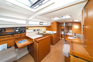 A compact galley with a stove, sink, and control panel, surrounded by wooden cabinetry and seating areas. - Sun-Kissed Sailing Adventure in the Sporades Islands from Volos, Thessaly (Volos)