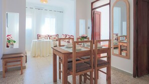 Un coin repas avec des meubles en bois, une table, des chaises et un miroir.