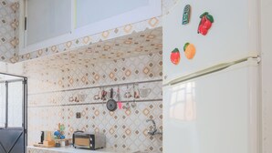 Une cuisine équipée d’un réfrigérateur blanc, d’un four à micro-ondes, d’un grille-pain et d’un évier.