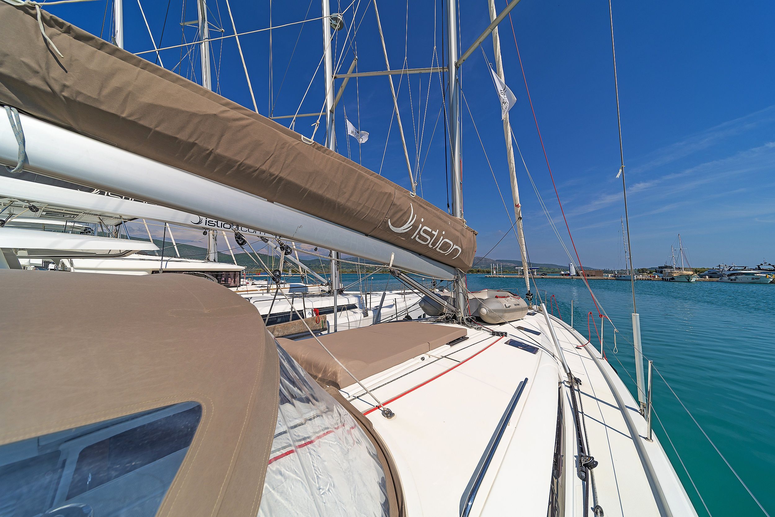 A sailboat docked at a marina with clear skies.