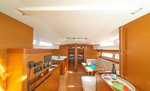 A compact kitchen with a stove, a microwave, and a small refrigerator. There is a dining area with a table and chairs.