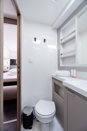 Ein kleines Badezimmer mit Toilette, Waschbecken und Spiegel.