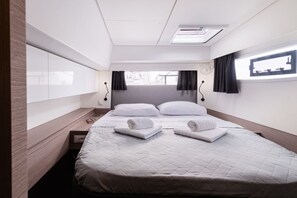 Ein Hotelzimmer mit Bett, Nachttischen, einem Fenster und Blick ins Freie.