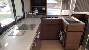 Una cocina compacta con un lavabo, estufa y armarios.