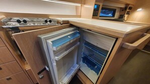 Una cocina compacta equipada con refrigerador, microondas y estufa.