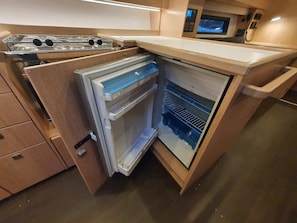 Eine kleine Küche mit integriertem Kühlschrank, einer Mikrowelle und einem Herd.
