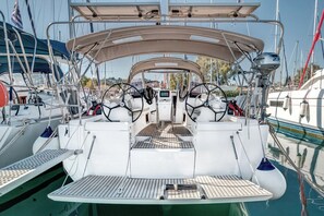 Ein Bootsdeck mit Steuerpult, Navigationseinrichtungen und einer Sitzgelegenheit.