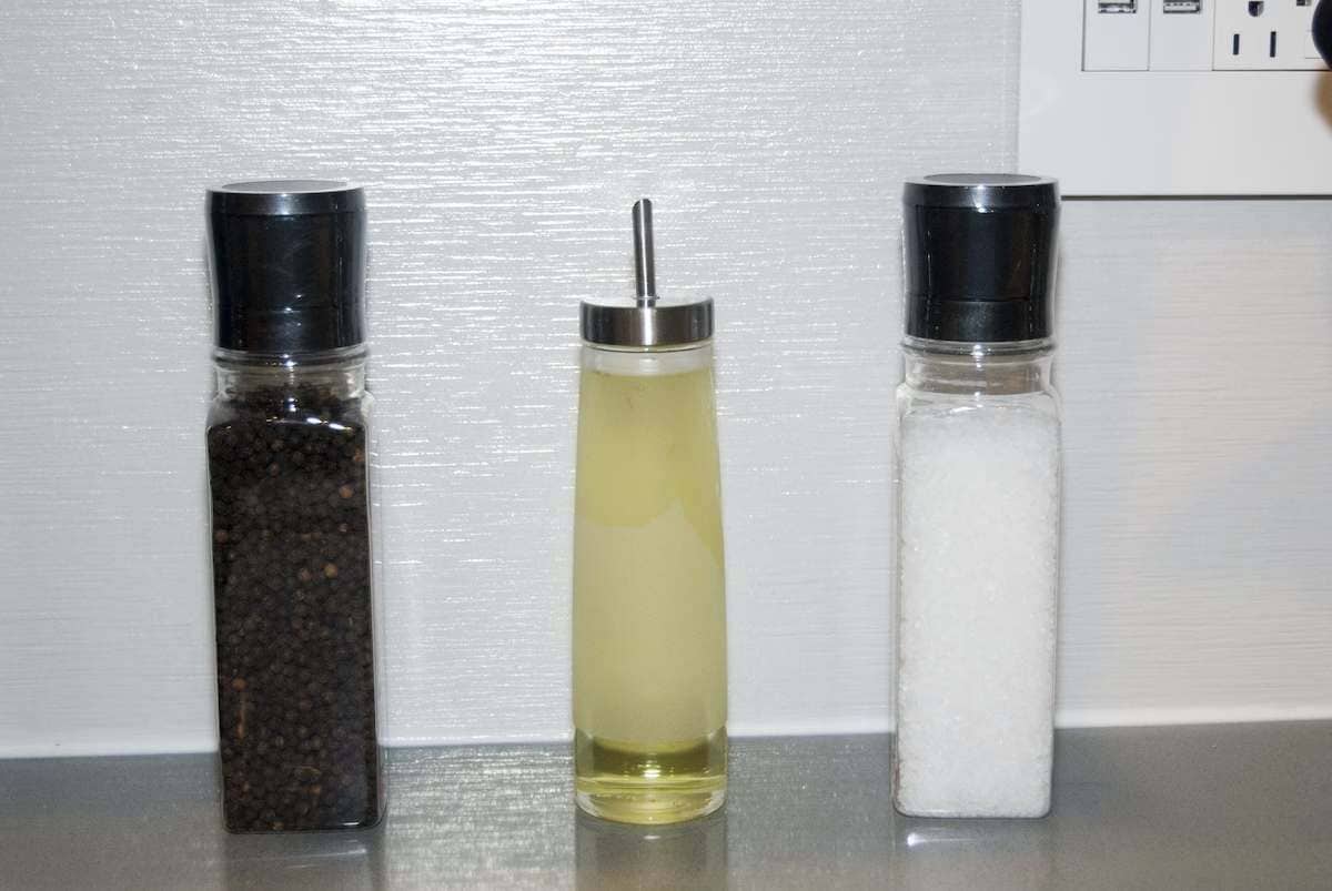 Three condiment bottles on a countertop.