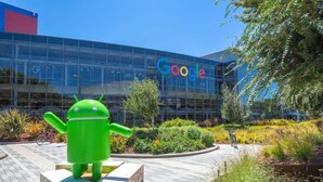 Un edificio Google con una grande statua del robot Android di fronte.