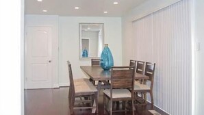 A dining room with a rectangular table, six chairs, a blue vase, a mirror, and a white door. - Silicon Valley Stays Casa Uno (Mountain View)