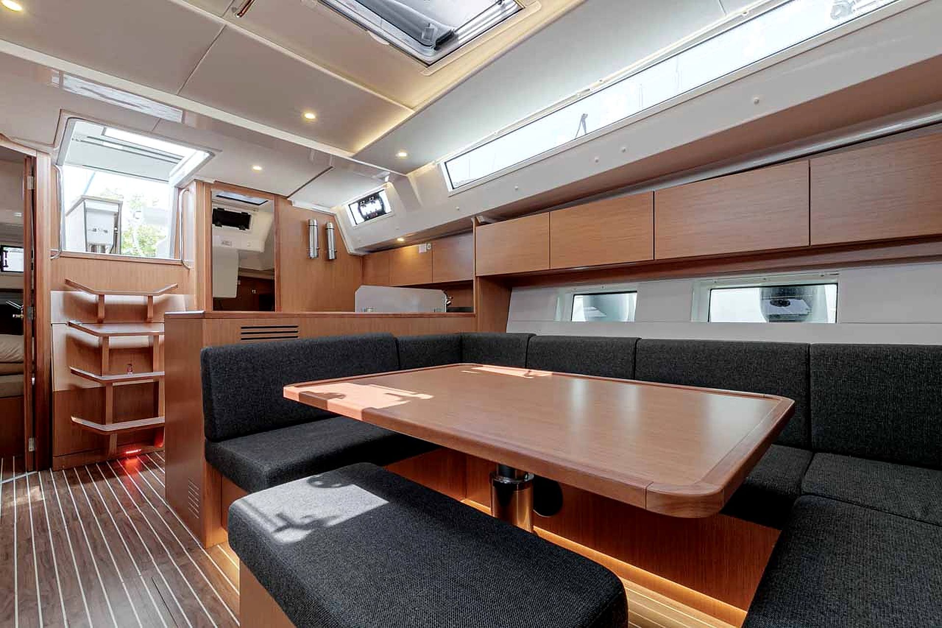A compact interior with a central table, cushioned seating, and a window providing natural light.