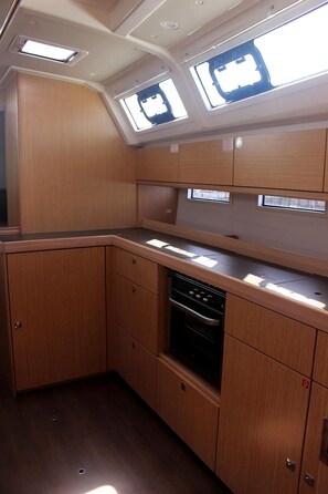 A compact kitchen with built-in appliances, wooden cabinetry, and skylights. - Sun-Kissed Sailing Adventure in the Sporades Islands from Volos, Thessaly (Volos)