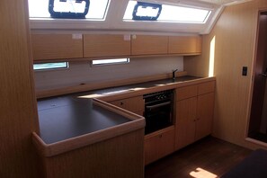 A compact kitchen with wooden cabinets, a dishwasher, and a skylight. - Sun-Kissed Sailing Adventure in the Sporades Islands from Volos, Thessaly (Volos)
