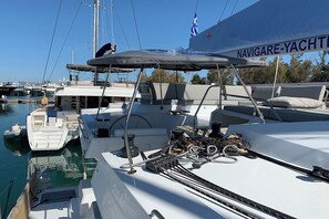 Un yacht était amarré dans une marina, avec une terrasse couverte, un volant et un pavillon.