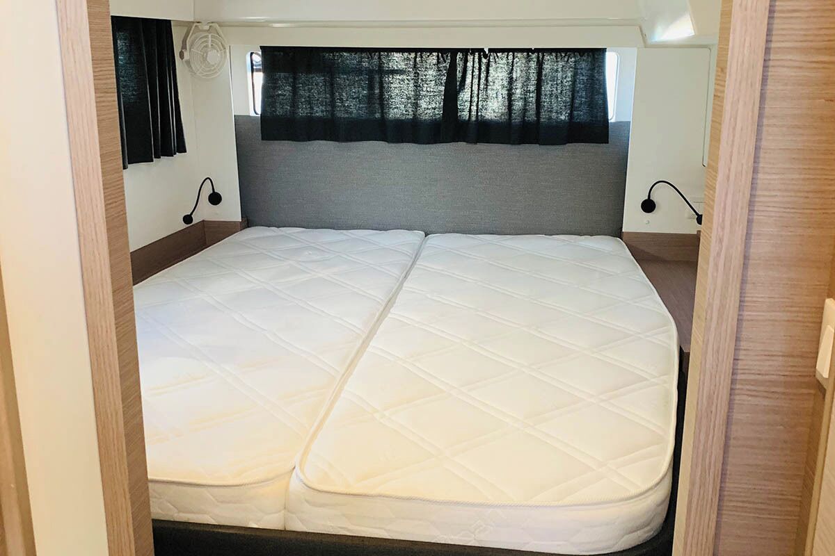A bed with a quilted mattress, a headboard, and two bedside lamps.