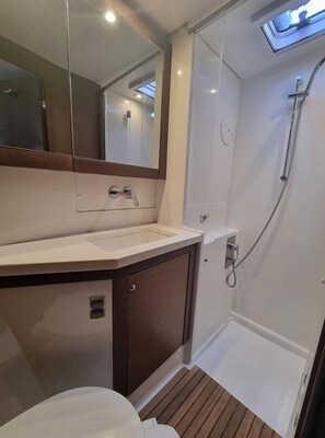 Ein Badezimmer mit Waschbecken, Spiegel und Dusche.