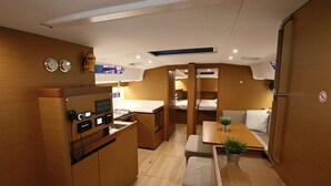 Une cabine compacte et bien éclairée, équipée d’un coin cuisine, d’un espace repas et d’un couchage.