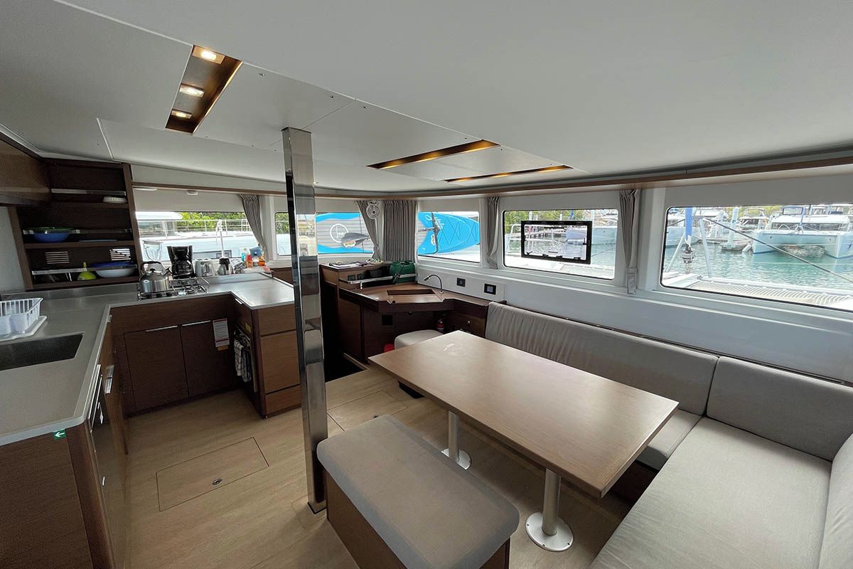 Une cuisine moderne avec un coin repas, de grandes fenêtres et une vue sur le port de plaisance.