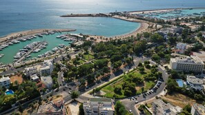 An aerial view of a coastal town with a marina, roads, and buildings. - Sun-Kissed Sailing Adventure in the Saronic Islands (Elliniko)