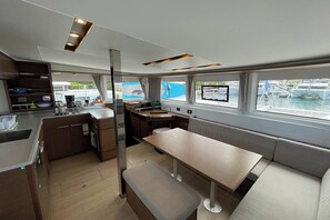 A modern kitchen with a dining area, large windows, and a view of the marina.
