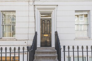 A building with a white facade, a black door with the number 241, and a black iron fence. - Stylish Angel Studio Near Regent’s Canal (London)