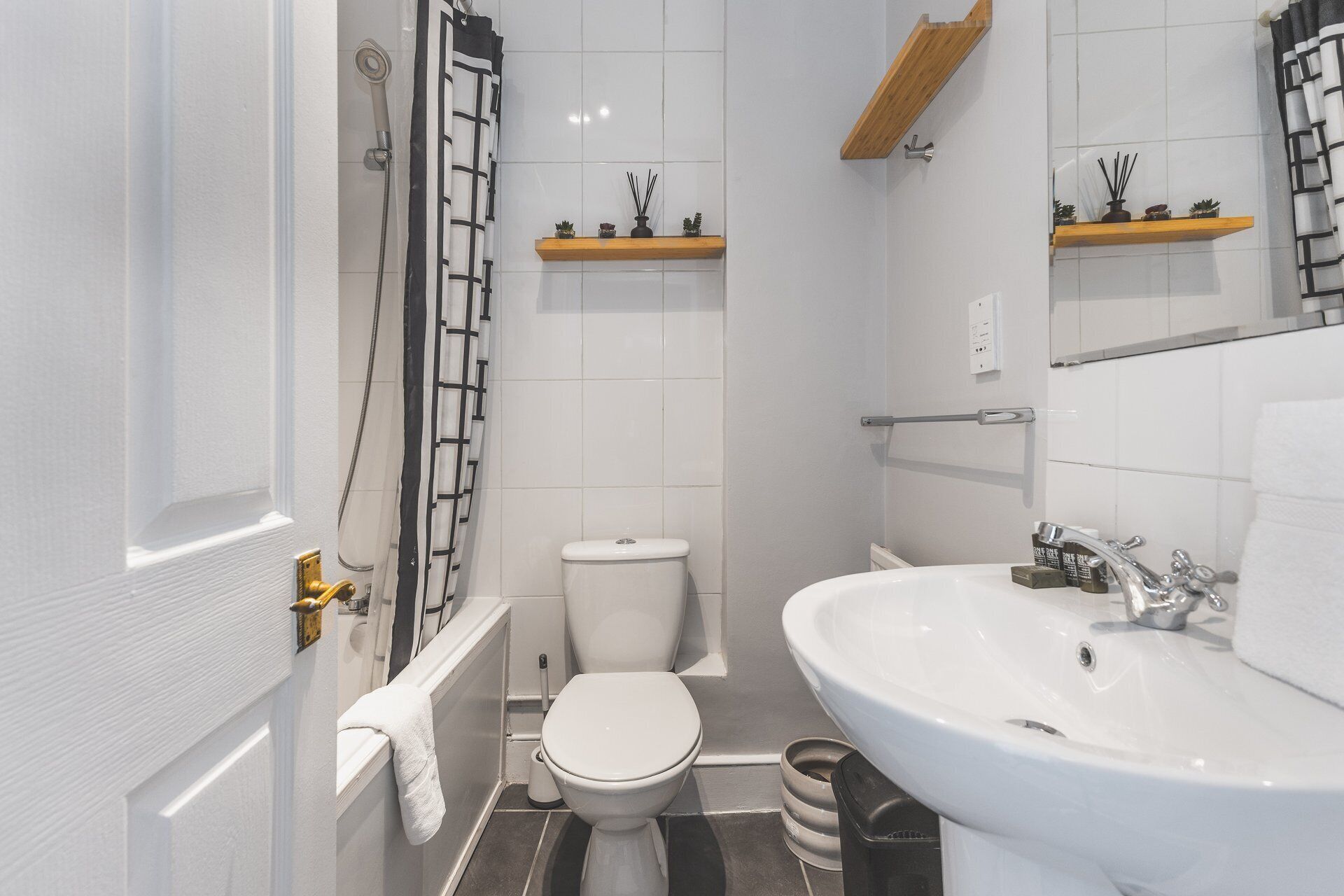 A compact bathroom with a toilet, sink, and shower.