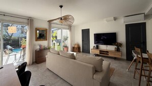 Ein Wohnzimmer mit einer Couch, Fernseher und Essbereich.