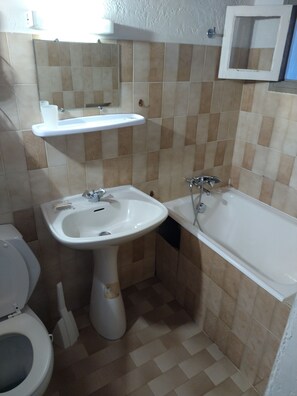 Ein Badezimmer mit Toilette, Waschbecken und Badewanne.