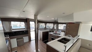 Une cuisine compacte dotée d’un îlot central, d’un coin repas et offrant une vue sur le port de plaisance.