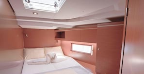Una cabaña pequeña y bien iluminada, con una cama, una ventana pequeña y espacio de almacenamiento integrado.