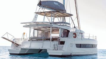 Un yacht blanc doté d’un pont couvert, d’une bouée de sauvetage et du numéro 46 peint sur la coque.