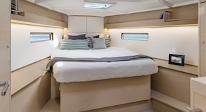A compact, well-lit bedroom with a bed, bedside tables, and a skylight. - Sun-Kissed Sailing Adventure in Islas Sarónicas (Alimos)