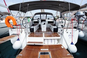 Ein Bootsdeck mit Steuer, Rettungsflossen und einer Wasserpumpe.