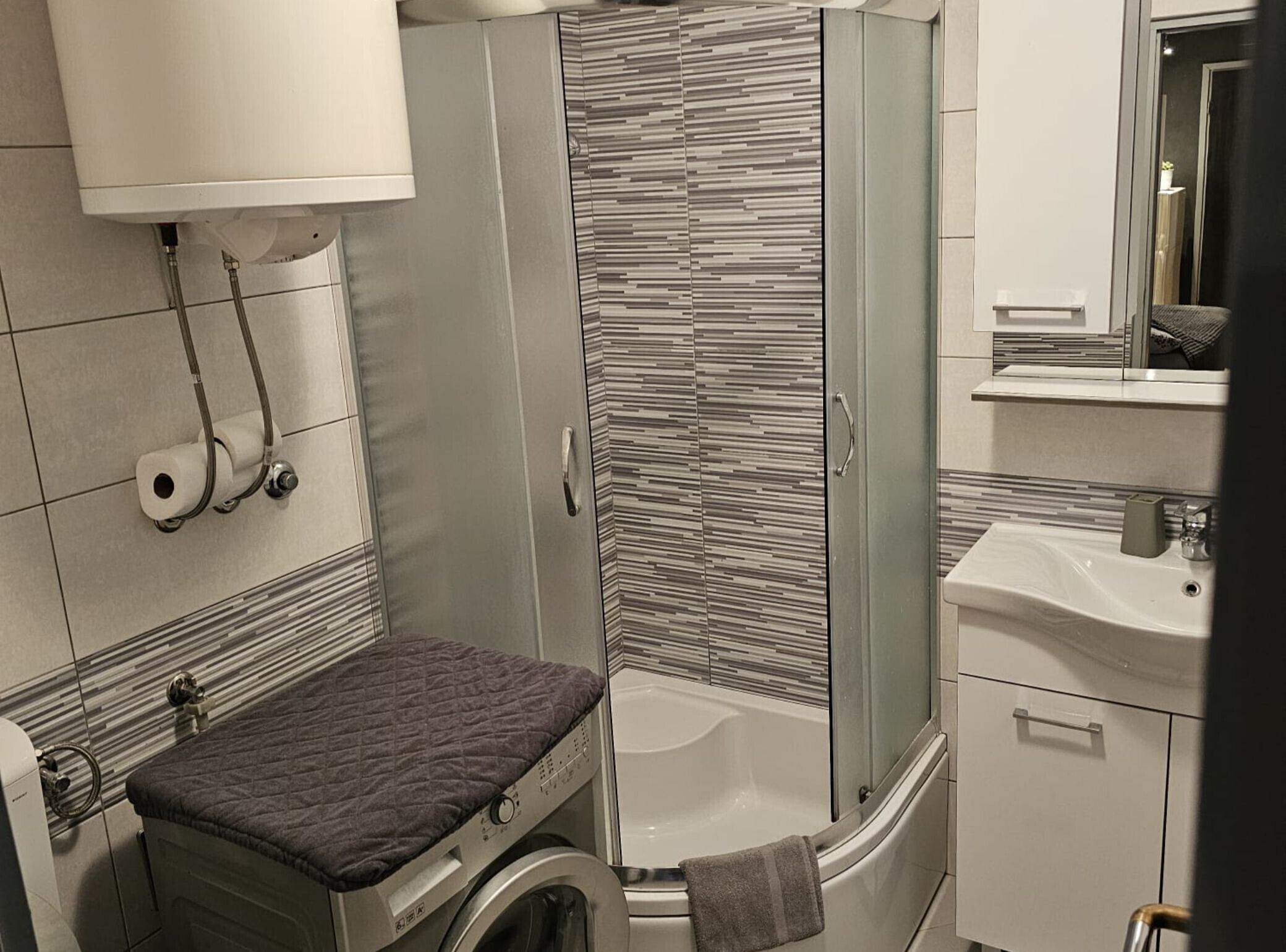 Un baño moderno con ducha, inodoro y lavabo.