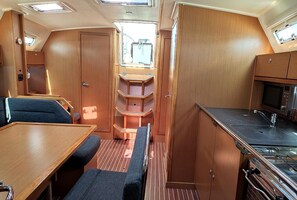 A compact RV interior with a kitchenette, a dining area, and a small seating space.