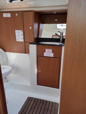 A compact bathroom with a toilet, sink, and shower area.